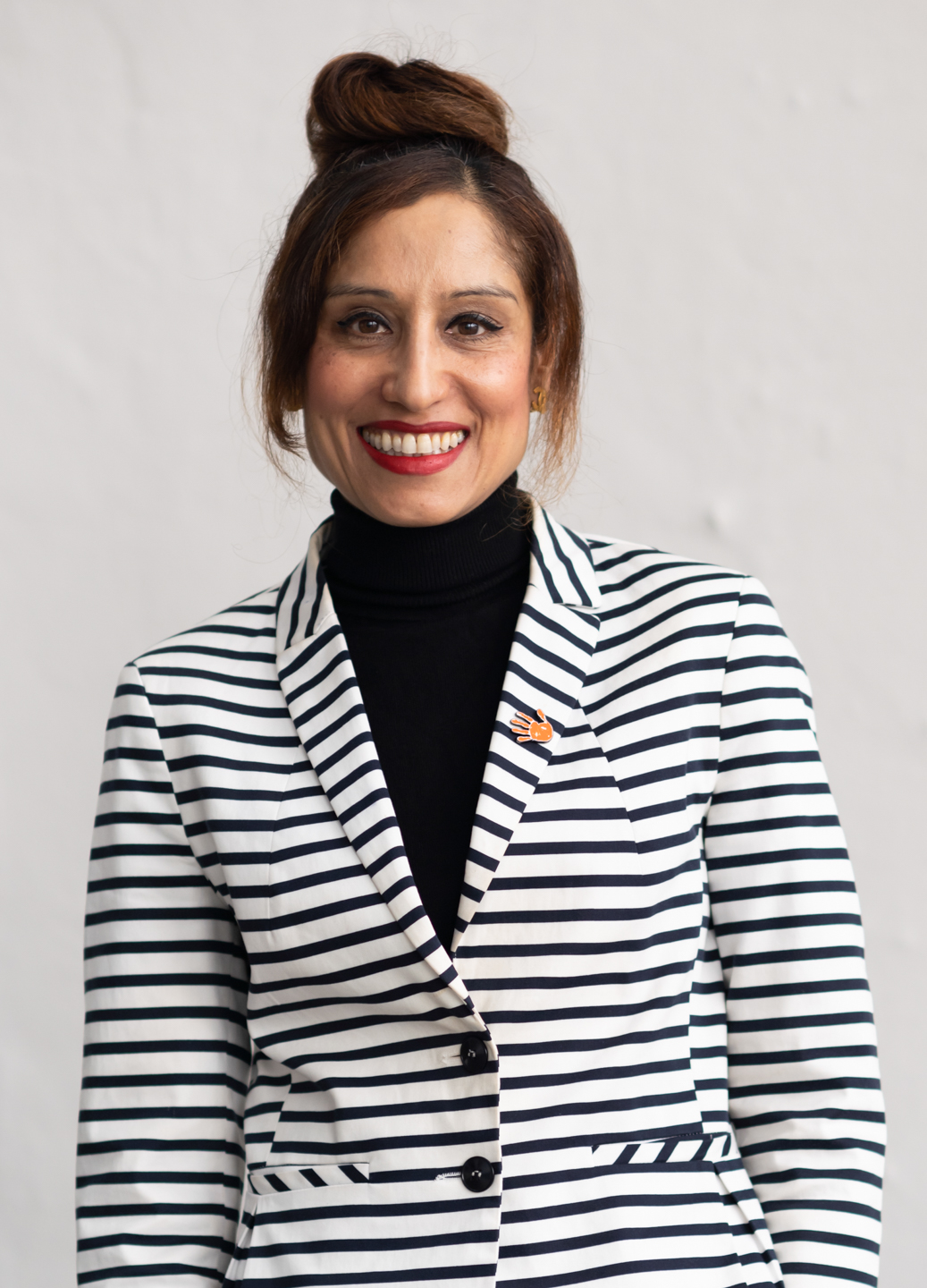 A person smiling at camera
Description automatically generated